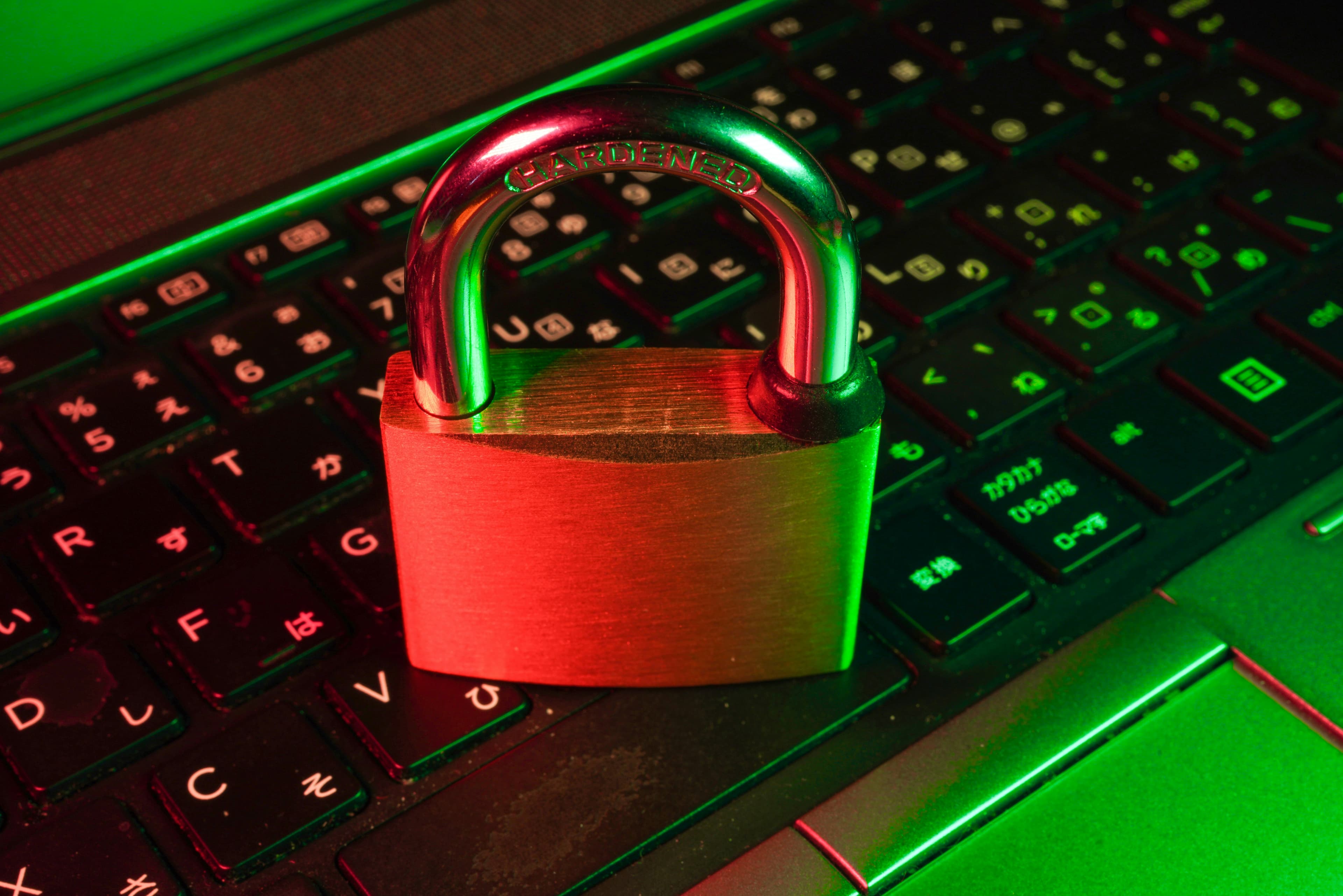 Red padlock resting on a black computer keyboard, representing software security